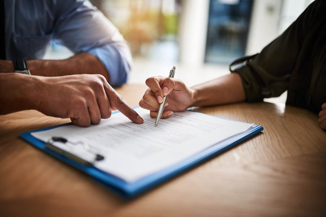 Dos personas revisando y firmando documentos de logística